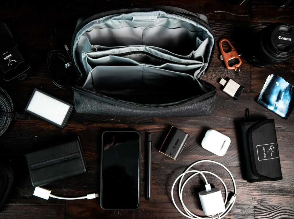 A flat lay of various electronic gadgets and accessories arranged neatly on a dark wooden surface.