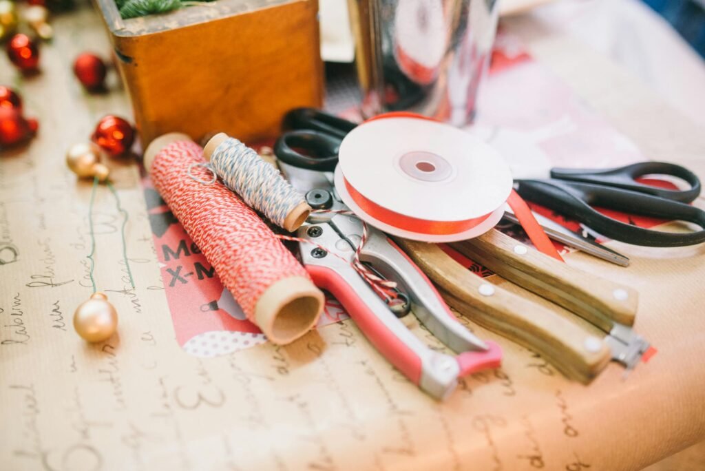 A close-up of various crafting supplies and tools on a table for festive DIY projects.
