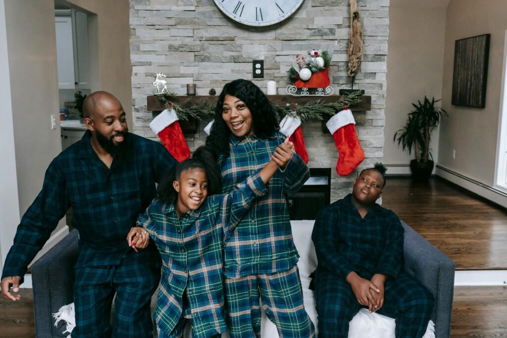 Cheerful African American family in same clothes gathering in cozy living room decorated with Christmas stockings