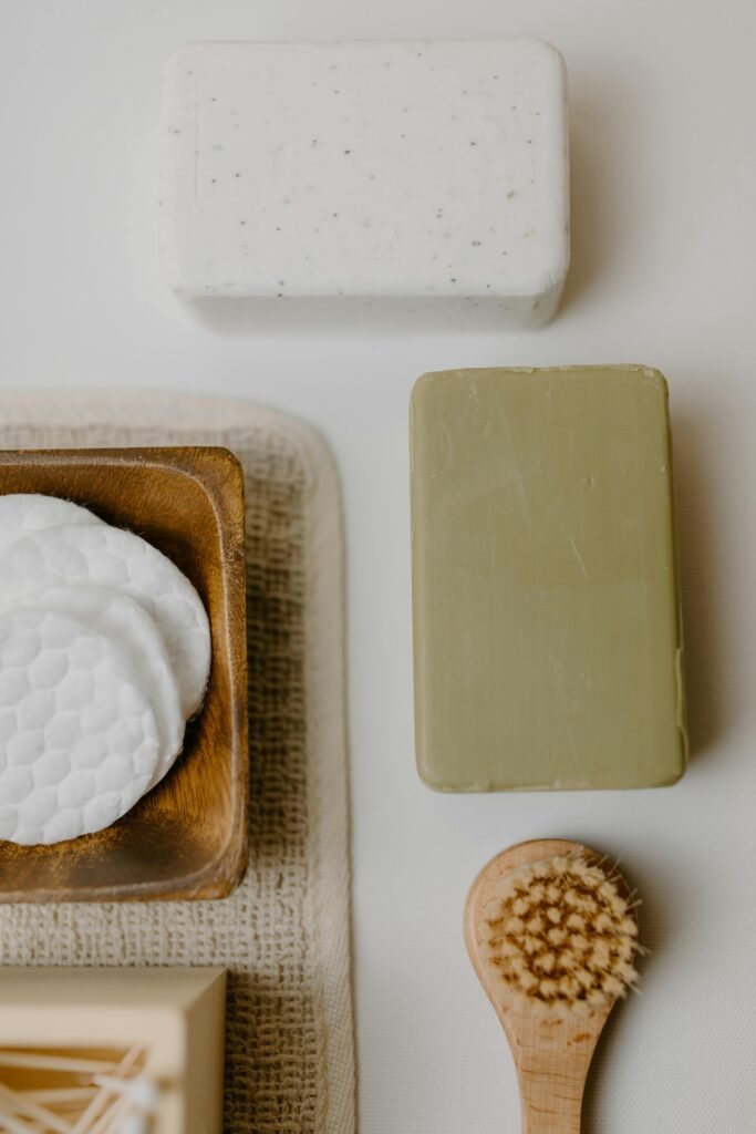 A minimalist flat lay of natural bath products including soap and brushes.