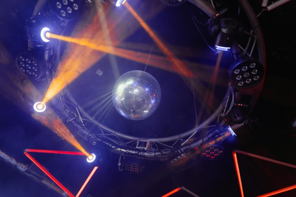Vibrant nightclub scene with colorful lights and disco ball, creating a lively atmosphere.